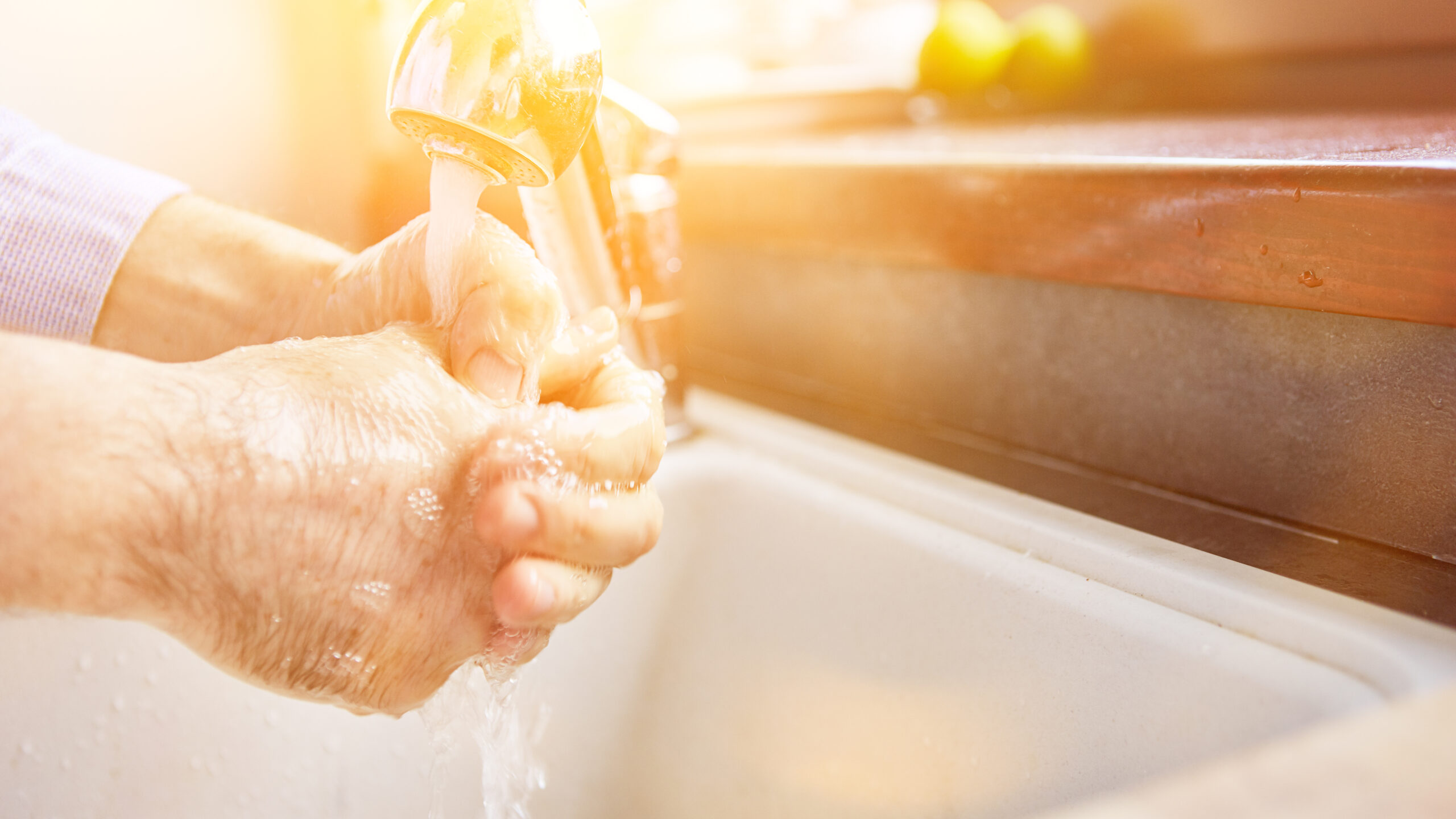 Elderly woman washing hands with soap for coronavirus